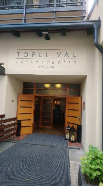 Ročno slikan napis Topli val nad vhodom restavracije